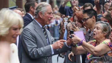 Prince Charles and Camilla meet the crowd in Sydney's Martin Place. He received many presents for his grandchildren, including a rattle, booties and a giant lollipop.