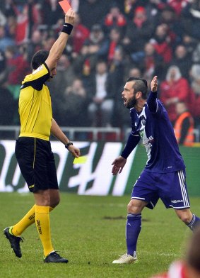Steven Defour is sent off after kicking the ball at the home fans.