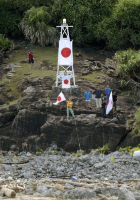 Japanese activists wave the national flag in front of a lighthouse on one of the disputed East China Sea islands, known as Senkaku in Japanese and Diaoyu in Chinese, in 2012.