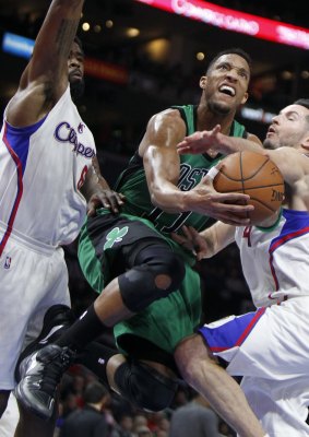 Defensive presence: Clippers centre DeAndre Jordan and guard JJ Redick try to stop Boston Celtics guard Evan Turner from taking a shot in Los Angeles.