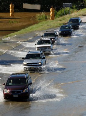 Motorists drive through the floodwaters from Hurricane Matthew washing over a  highway near Rocky Mount, North Carolina.