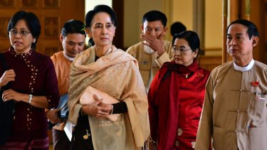 Myanmar opposition leader Aung San Suu Kyi, centre, leaves along with lawmakers after the final session of Myanmar's out-going parliament.