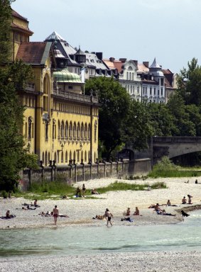 People swim and relax on the Isar River in Munich.