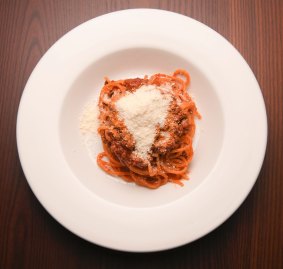 Spaghetti bolognese loaded with powdered parmesan.