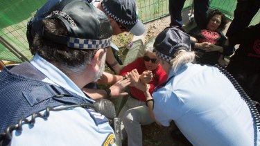A protester is physically removed by police at St Peters on Friday.