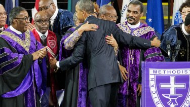 President Barack Obama is embraced by clergy members after delivering the eulogy at the funeral service for Clementa Pinckney.