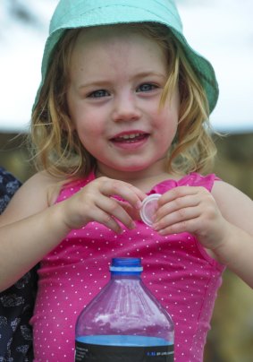 Eleanor Anderson, 2, of Kambah, shows how recycling should be done. The ACT government has launched a new campaign encouraging Canberrans to remove lids from containers before putting them in the recycling bin. 