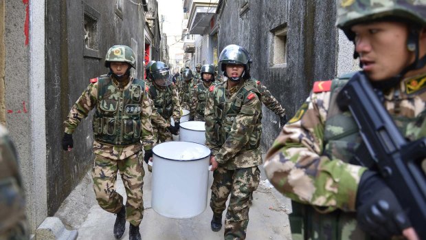 Paramilitary policemen carry seized crystal meth at Boshe village, Guangdong province,  after a massive raid on December 29.