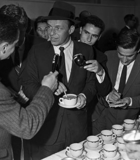 Frank Sinatra contemplates a cup of tea as he is met by reporters at Sydney Airport in 1961.