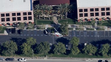 A police heicopter hovers around the Inland Regional Center in San Bernardino, where the mass shooting occurred.