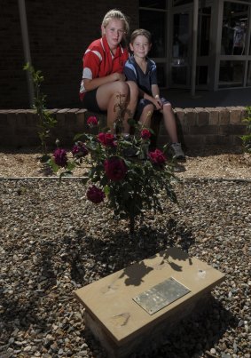 The memorial to Abbie Mewburn, a former student of Holy Family Primary School in Gowrie, was vandalised recently. At the site is her older sister 12-year-old Micaela Mewburn of Monash and one of Abbie's school friends, Lucas Ryan, 7,  of Isabella Plains.