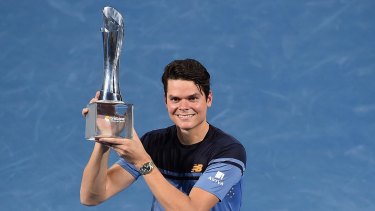 Milos Raonic of Canada holds the Roy Emerson trophy after winning the Brisbane International.