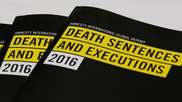 Copies of reports on the death penalty are displayed during a press conference of Amnesty International in Hong Kong.
