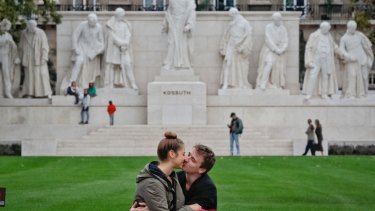 A couple kiss in front of the Kossuth memorial during a protest by opposition parties against Hungarian Prime Minister Viktor Orban's policies on migrants in Budapest.