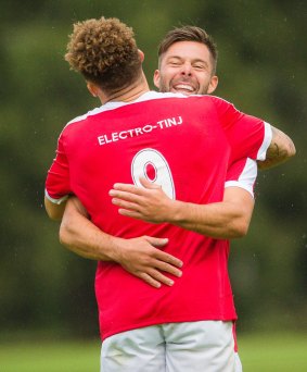 Canberra FC's Thomas James is hugged by a teammate after scoring a goal.