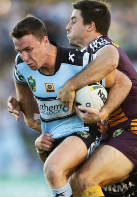 James Maloney of the Sharks is tackled by Ben Hunt.