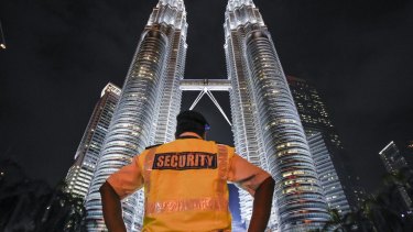 A security guard stands guard in front of Malaysia's iconic building, Petronas Twin Towers in Kuala Lumpur, Malaysia.