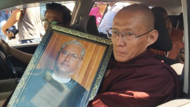 A Buddhist monk holds a portrait of Ko Ni, who spoke out about how the constitution stacked power in the hands of the military and was inconsistent with democracy.  
