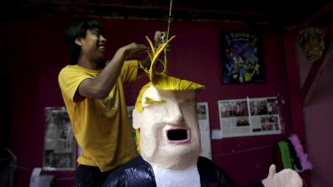 A worker hangs a pinata depicting US Republican presidential candidate Donald Trump at a workshop in Reynosa, Mexico.