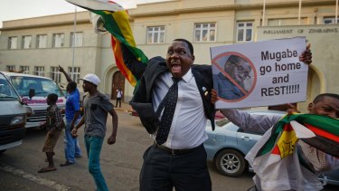 Zimbabweans celebrate outside the parliament building immediately after hearing the news that President Robert Mugabe had resigned, in downtown Harare, Zimbabwe.