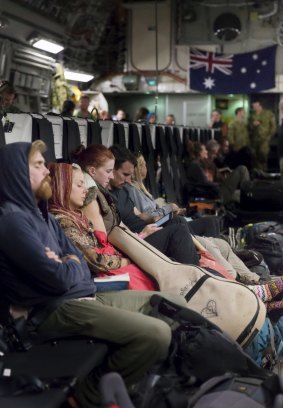 Australian citizens reast on board a Royal Australian Air Force C-17A Globemaster aircradt after being evacuated from Kathmandu to Thailand