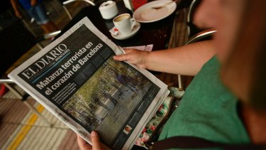 A woman reads about the Barcelona attack in a Spanish regional newspaper on Friday.