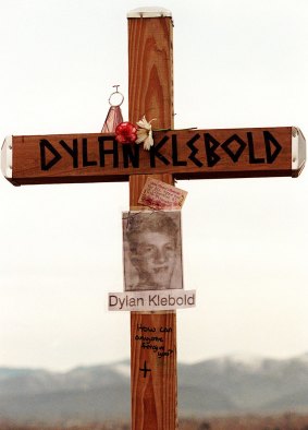 A cross bearing the name and likeness of Dylan Klebold and a message "How can anyone forgive you?" on a hill in Littleton, Colorado in 1999.