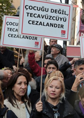Turkish men and women protest the bill. The placard reads: "Punish the rapist, not the child."