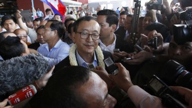 Cambodia's opposition leader Sam Rainsy, centre, faces arrest if he returns to his country as early as Monday