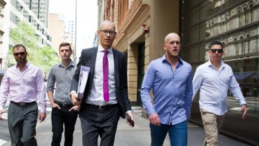 Shane Housego, Christian McDonald, Chris Sheehy and Steven Rapisarda join lawyer Nicholas Stewart (centre) to lodge papers at the NSW Civil and Administrative Tribunal in Sydney. 