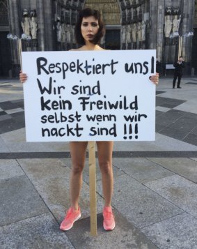 Swiss performance artist Milo Moire holds a sign "Respect us! We are no fair game even when we are naked!!!" as she protests naked in front of the Cologne, western Germany, cathedral on Friday.