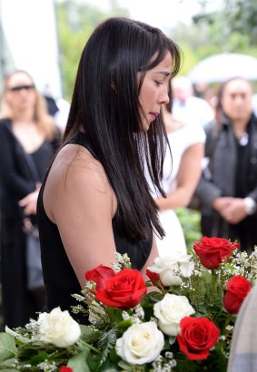 A mourner looks over Tara Brown's coffin.