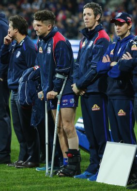 The Bulldogs' Tom Liberatore waits on the sideline, on crutches, during the round 19 match against Geelong.