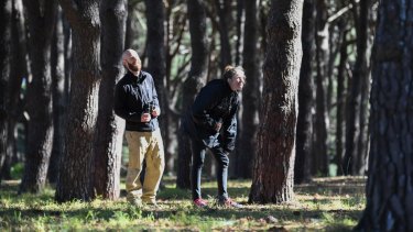 Wildlife ecologist John Martin and researcher Jessica Rooke look for yellow-tailed black cockatoos in 
Sydney's Centennial Park.