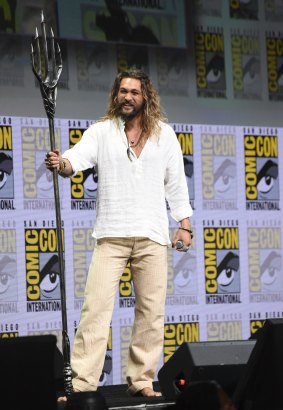 Jason Momoa poses with his Aquaman trident at Warner Bros' Justice League panel.