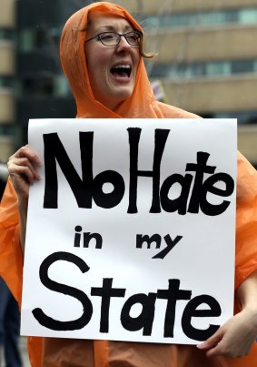 Bethany Mead holds a sign on the street in Appleton, Wisconsin, before a Trump rally on Wednesday.