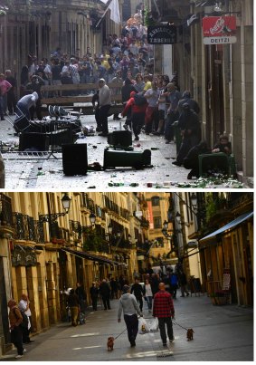 In this two photo combo, masked pro-independence followers of the Basque armed separatist group ETA, prepare to fight against the police during an illegal rally in San Sebastian, northern Spain, on Oct. 26, 2003, top, and people going for a walk in the same street of the old city on April 3, 2017.