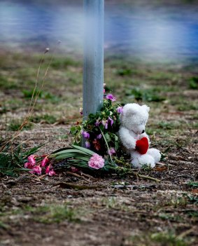 Flowers and a teddy bear left by mourners near Darebin Creek.