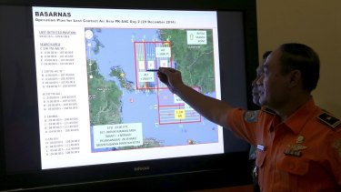 A member of the Indonesian National Search and Rescue Agency shows a map of the search area during a briefing.