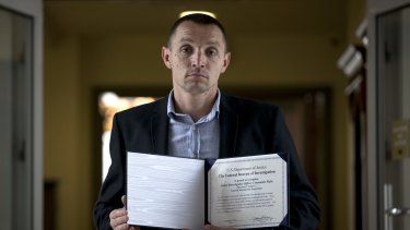 Former Moldovan police investigator Constantin Malic holds an award received from the FBI in Chisinau, Moldova. By the time of the award ceremony, his team had been disbanded.