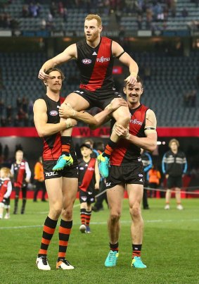 Essendon teammates chair Adam Cooney from the ground after the former Bulldog played his 250th and final AFL match on Sunday. 