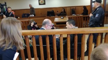 Bulgarian lawyer Histro Botev speaks with his client Australian John Zakhariev, right seated, in court in Sofia on Friday.