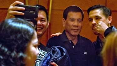 Will the real Duterte stand up?: Members of the Filipino community in China pose with a cut-out of their president. His ultimate goals on foreign policy remain unclear.