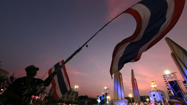 Disillusioned: A Thai anti-government demonstrator waves the national flag. 