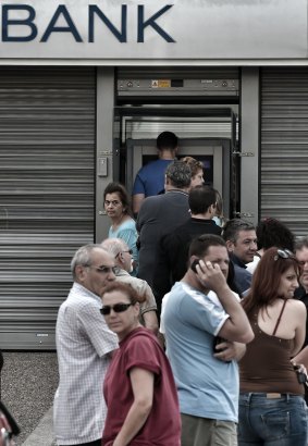 People stand in a queue to use ATM machines to withdraw cash at a bank in Athens. Increased uncertainty has heightened fears of a run on Greece's banks, though there was little sign of panic yesterday.