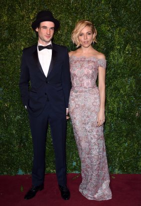 Barely there: Sienna Miller (with partner Tom Sturridge) gives a lesson in showing off a shoulder.