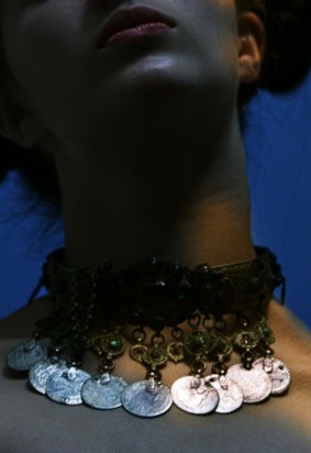 A photograph of a model wearing an elaborate necklace.