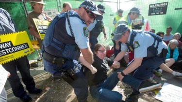 Police remove a protester from the site on Euston Road in the inner-city suburb of St Peters on Friday. 