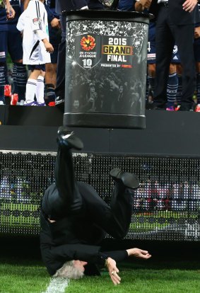 Football Federation Australia chairman Frank Lowy hits the AAMI Park turf after falling from the stage during the A-League grand final presentation ceremony. He was able to present the trophy after just a two-minute delay.