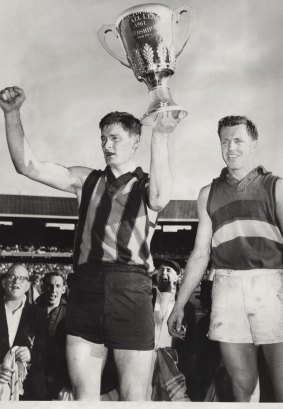 Hawthorn Skipper Graham Arthur holds aloft the 1961 premiership cup.